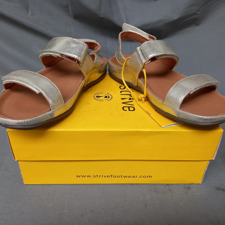 BOXED PAIR OF STRIVE SANDALS IN METALLIC GOLD SIZE 5