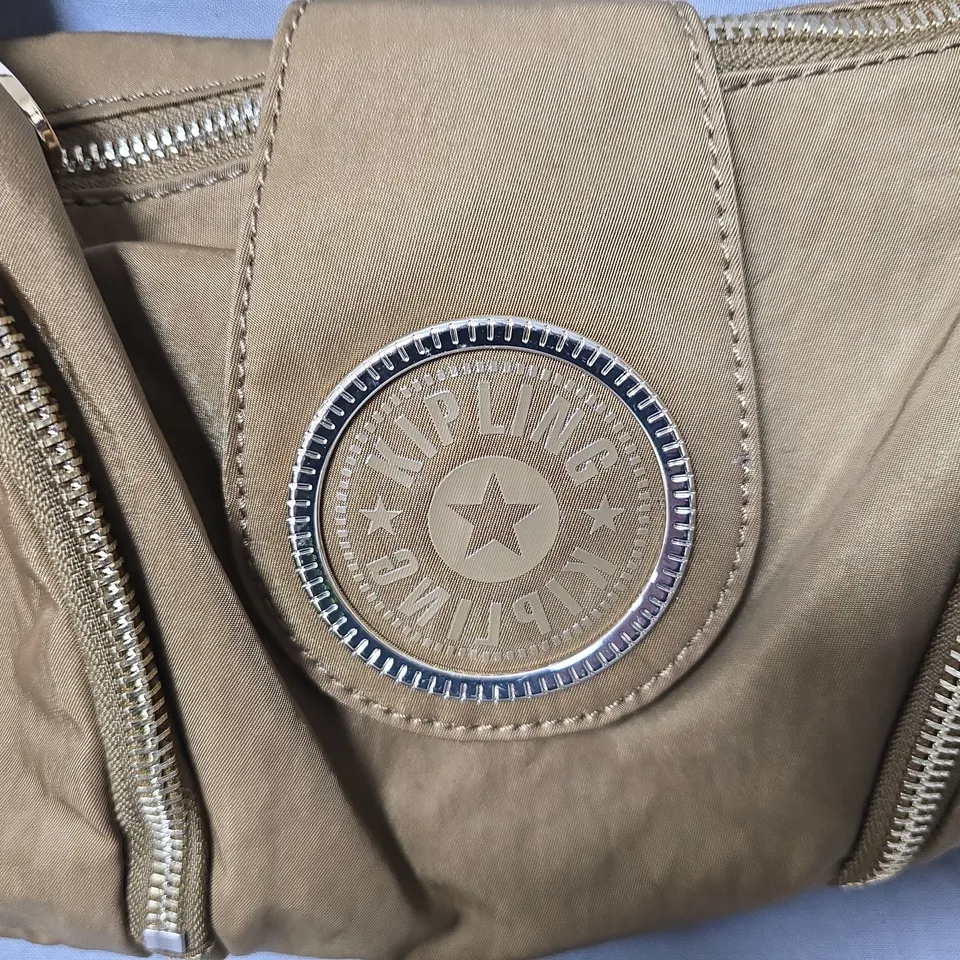 KIPLING TAN NYLON BAG WITH CIRCULAR METAL BADGE