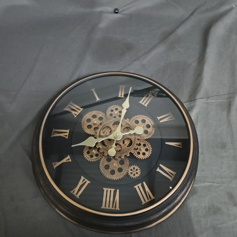 ROUND WALL CLOCK WITH EXPOSED BRASS GEARS, ROMAN NUMERALS, BLACK FINISH