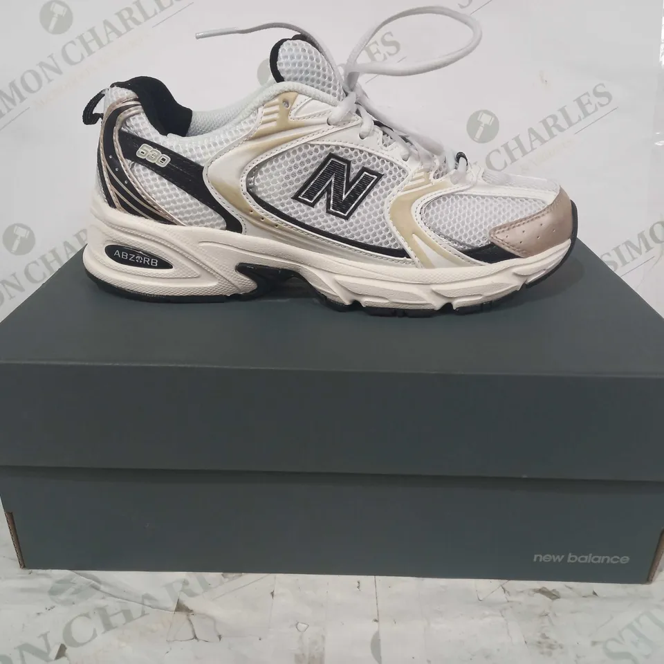 BOXED PAIR OF NEW BALANCE 530 SHOES IN WHITE/BLACK/GOLD UK SIZE 6.5