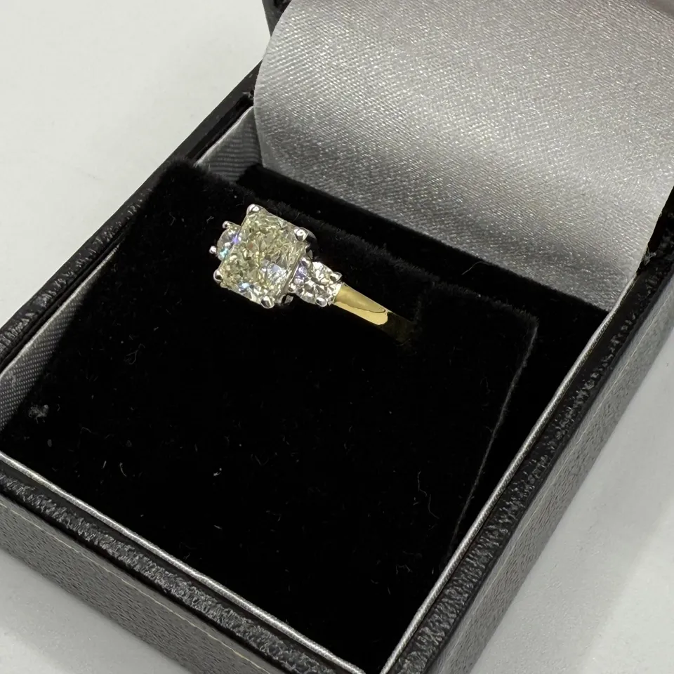 18CT GOLD RING SET WITH A NATURAL RADIANT CUT DIAMOND WITH A NATURAL DIAMOND TO EACH SHOULDER, WEIGHT +1.45CT