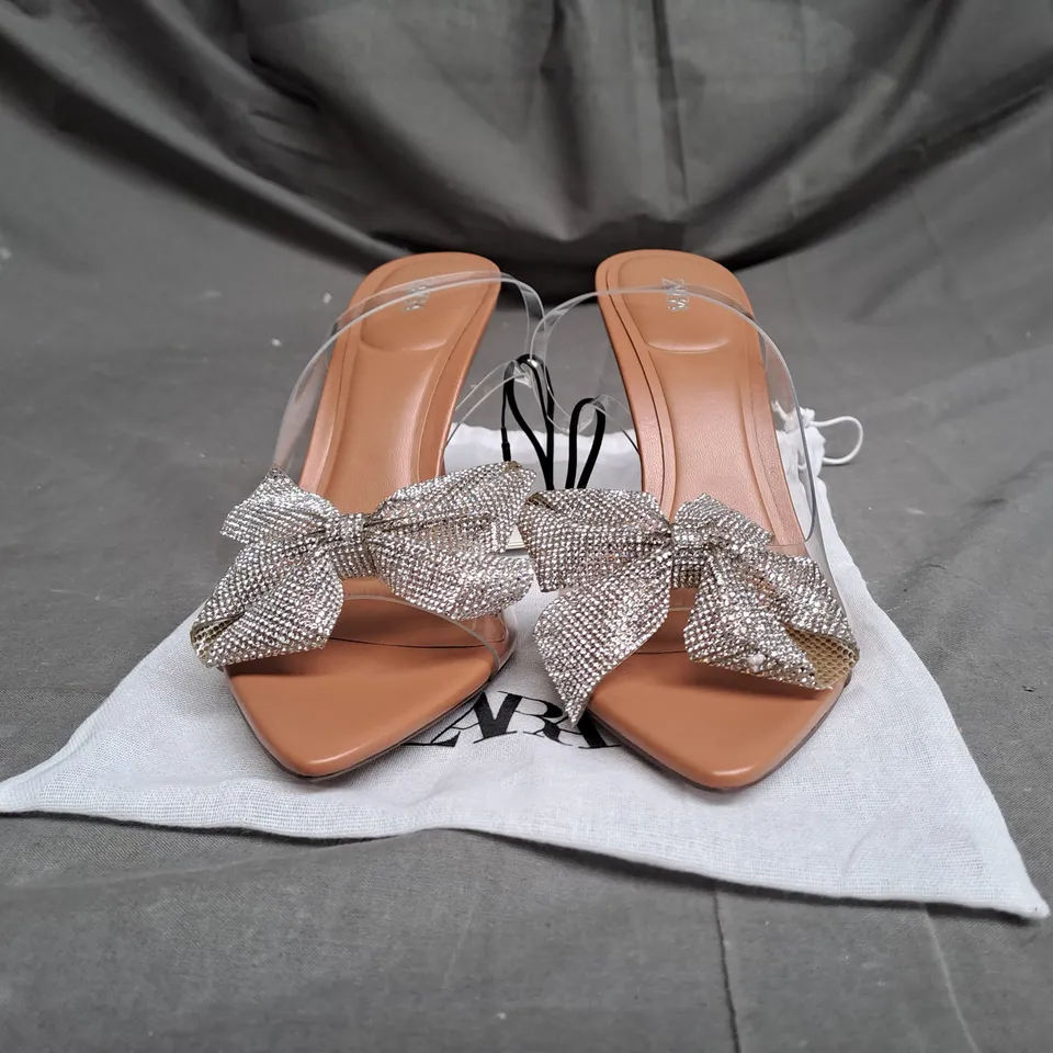 PAIR OF ZARA OPEN TOE HEELS IN CLEAR/TAN WITH SILVER BOW DETAIL SIZE 5