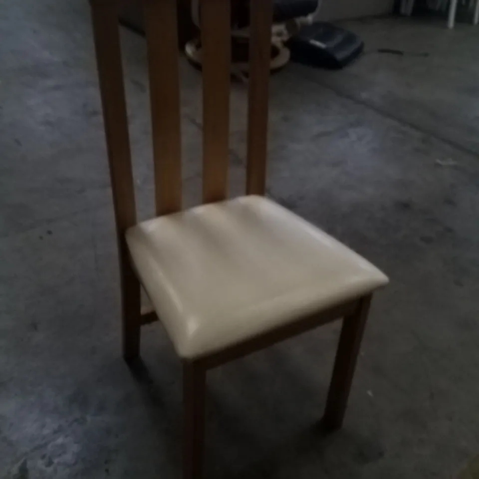APPROXIMATELY 4 OAK EFFECT SLATTED BACK DINING CHAIRS WITH CREAM FAUX LEATHER SEAT PADS