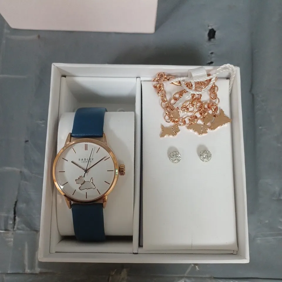 BOXED RADLEY BLUE LEATHER STRAP WATCH WITH 18CT RGP STUD EARRINGS AND CHARM BRACELET