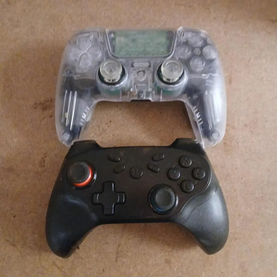 TWO ASSORTED VIDEO GAME CONTROLLERS TO INCLUDE; VIDEO GAME CONTROLLER WITH TRANSPARENT SHELL OVER BLACK BODY