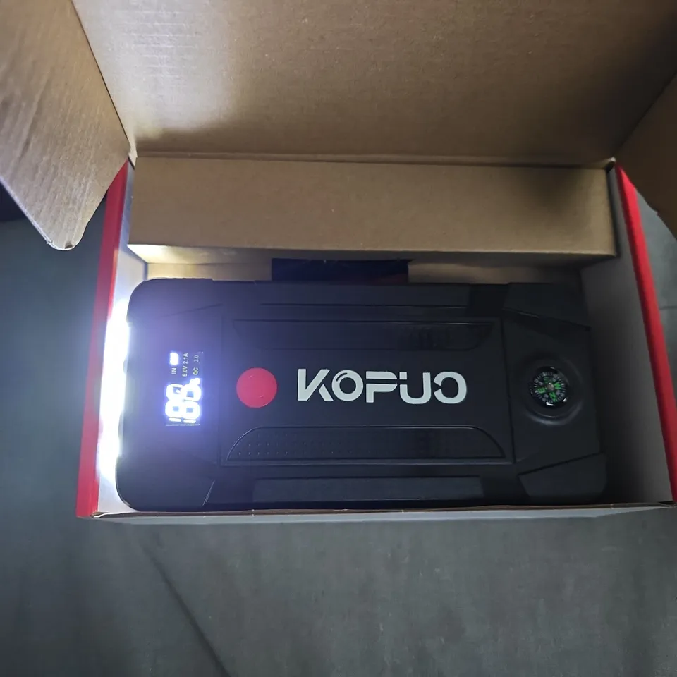 PORTABLE CAR JUMP STARTER – BLACK HANDHELD DEVICE IN RED BOX 