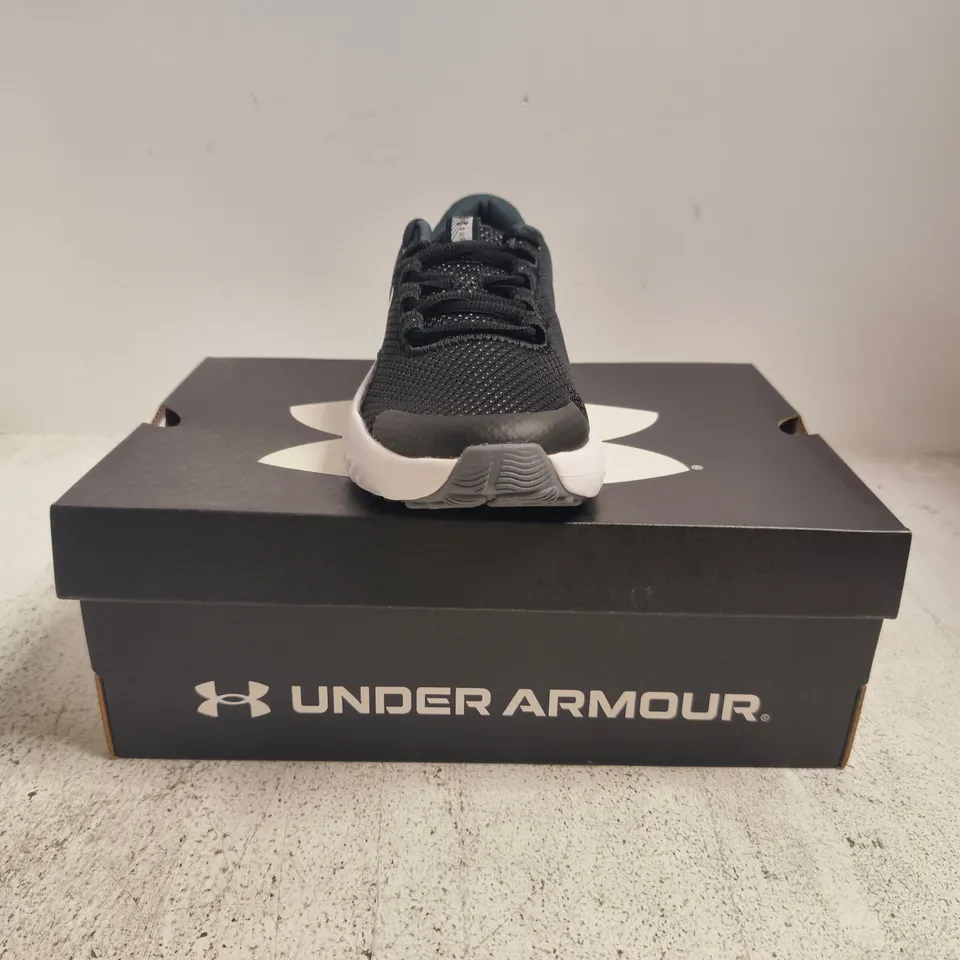 BOXED PAIR OF UNDER ARMOUR BGS SURGE 4 TRAINERS IN BLACK/WHITE SIZE UK 3