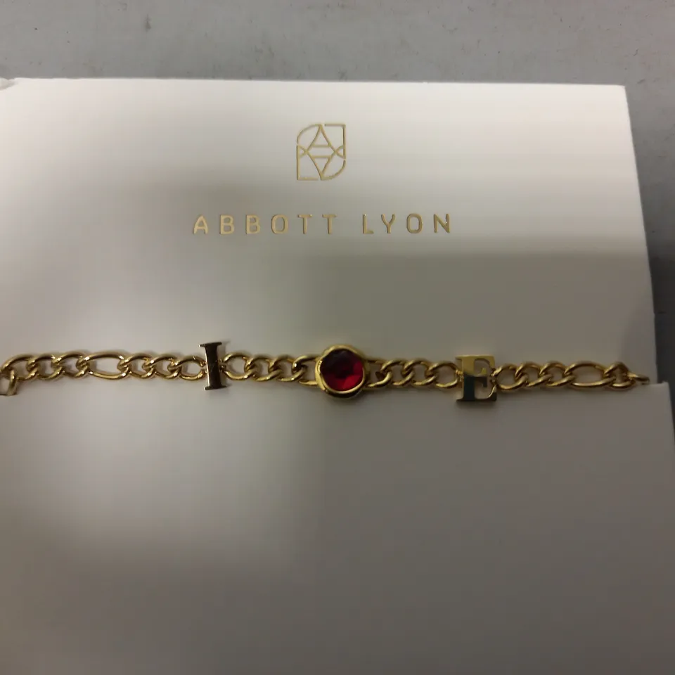 BOXED ABBOTT LYON CUSTOM INITIAL BRACELET IN GOLD W. RED JEWEL EFFECT
