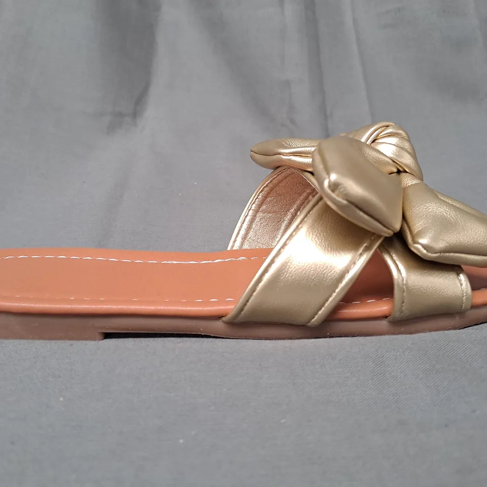 BOXED PAIR OF DESIGNER OPEN TOE FLAT SANDALS IN METALLIC GOLD W. BOW DETAIL EU SIZE 35