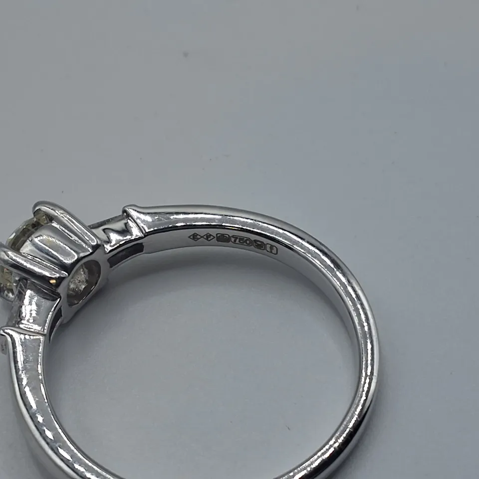 18CT WHITE GOLD RING SET WITH A NATURAL DIAMOND TO THE CENTRE AND A BAGUETTE TO EACH SHOULDER