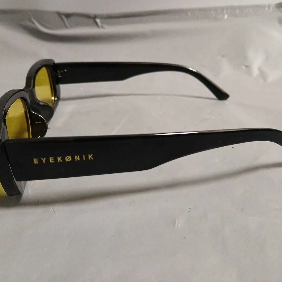 BOXED PAIR OF EYEKONIK BLACK FRAMED GLASSES WITH YELLOW TINT LENS