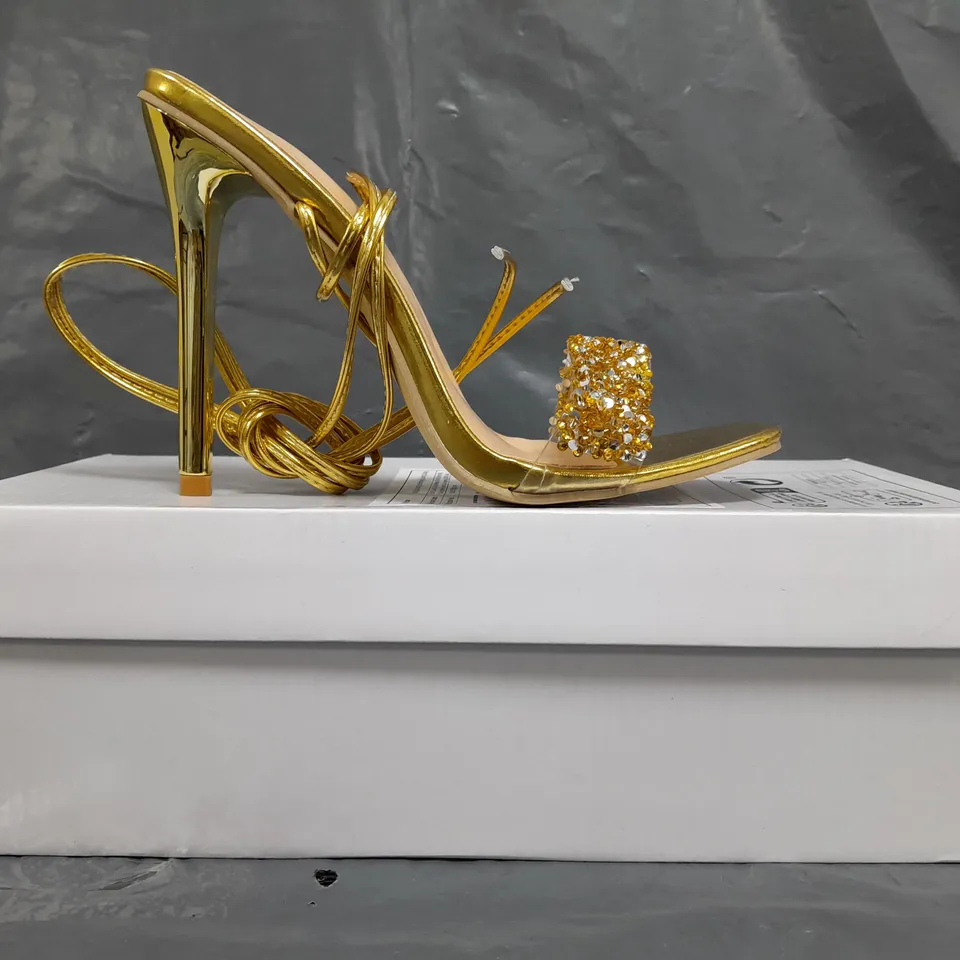 BOXED PAIR OF UNBRANDED HIGH HEELED STRAPPY SANDALS IN METALLIC GOLD W. JEWEL EFFECT SIZE EU 37