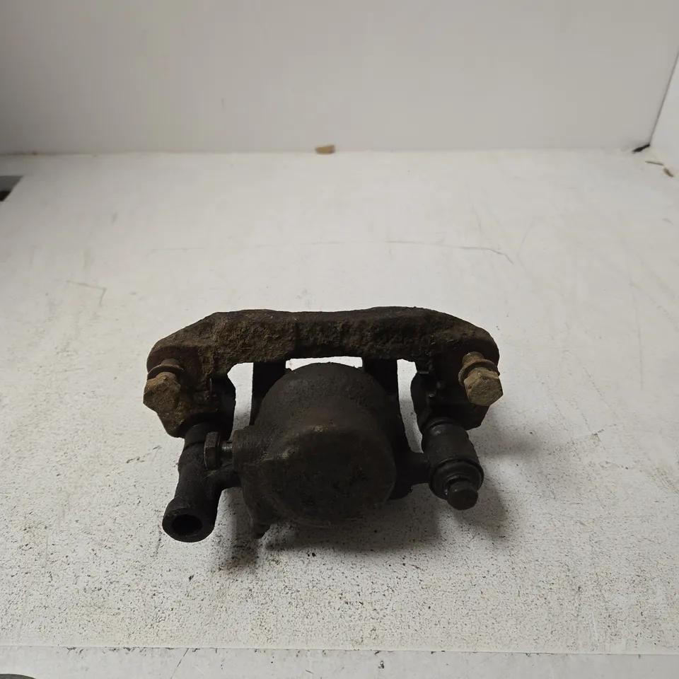 USED AUTOMOTIVE BRAKE CALIPER ASSEMBLY WITH MOUNTING BRACKET – RUSTY