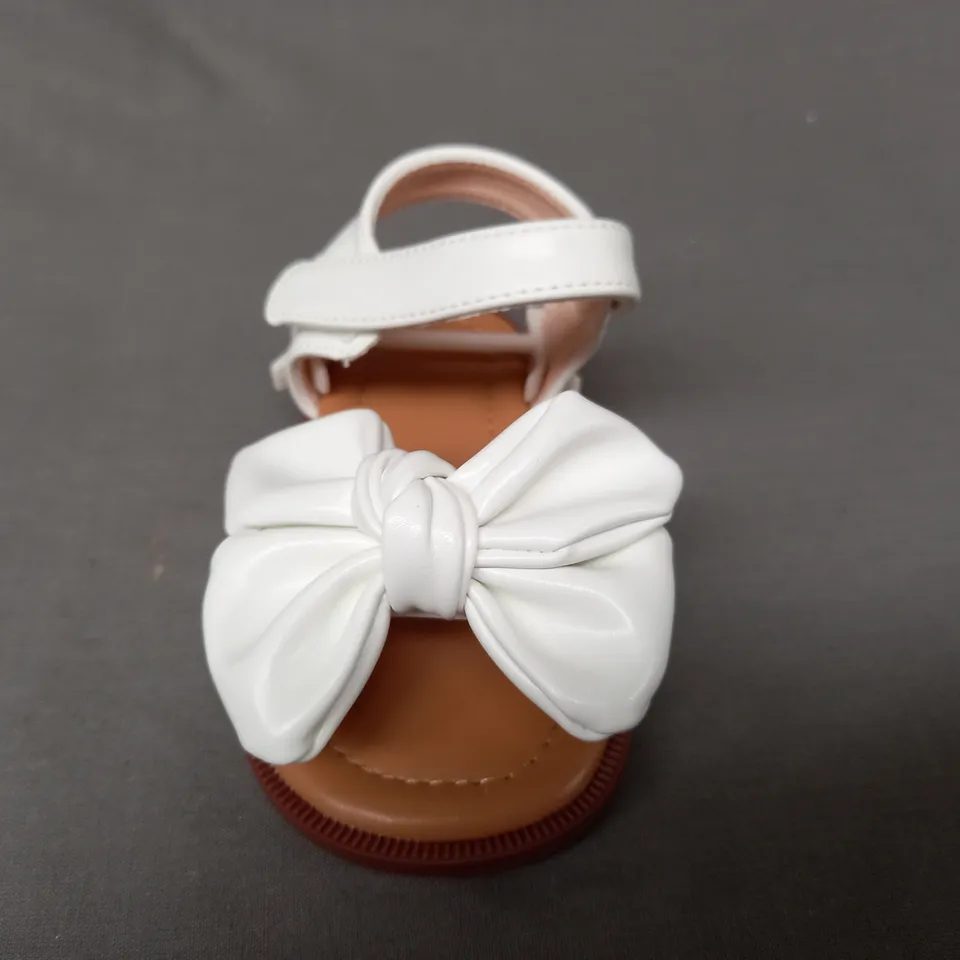 BOXED PAIR OF DESIGNER INFANT OPEN TOE SANDALS IN WHITE W. BOW DETAIL EU SIZE 20