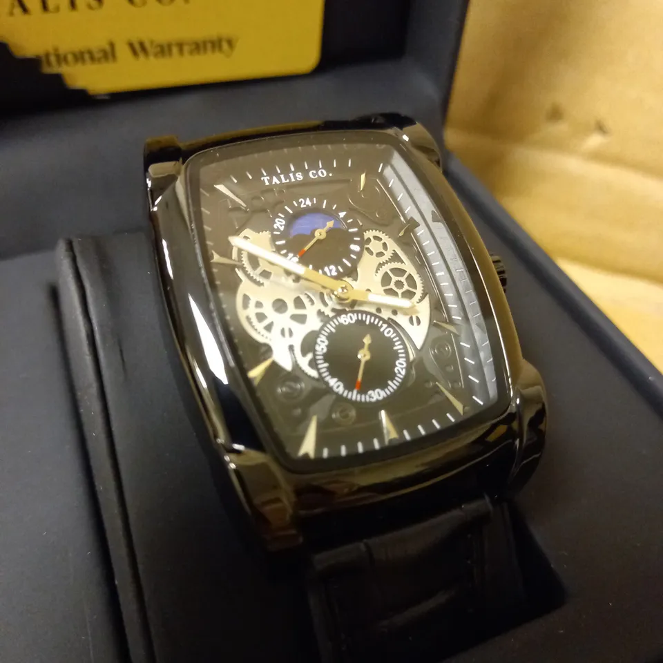 MENS TALIS CO WATCH, CHRONOGRAPH MOVEMENT. BLACK LEATHER STRAP, SLEEK BLACK/SILVER SKELETON DIAL