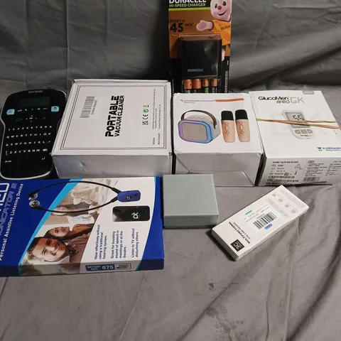BOX OF ASSORTED ELECTRONIC ITEMS : PORTABLE VACUUM CLEANER, GLUCOMETER KIT, AUDION PERSONAL LISTENING DEVICE & BATTERIES