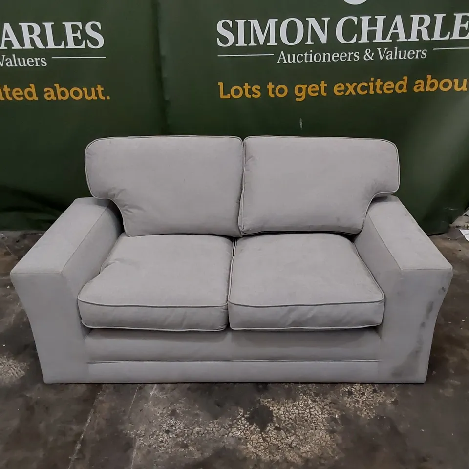 DESIGNER 2 SEATER UPHOLSTERED IN LIGHT COLOURED FABRIC 