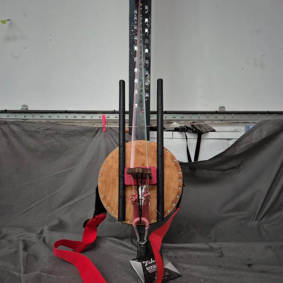 SITAR STYLE STRINGED INSTRUMENT WITH CIRCULAR WOODEN BODY AND LONG NECK