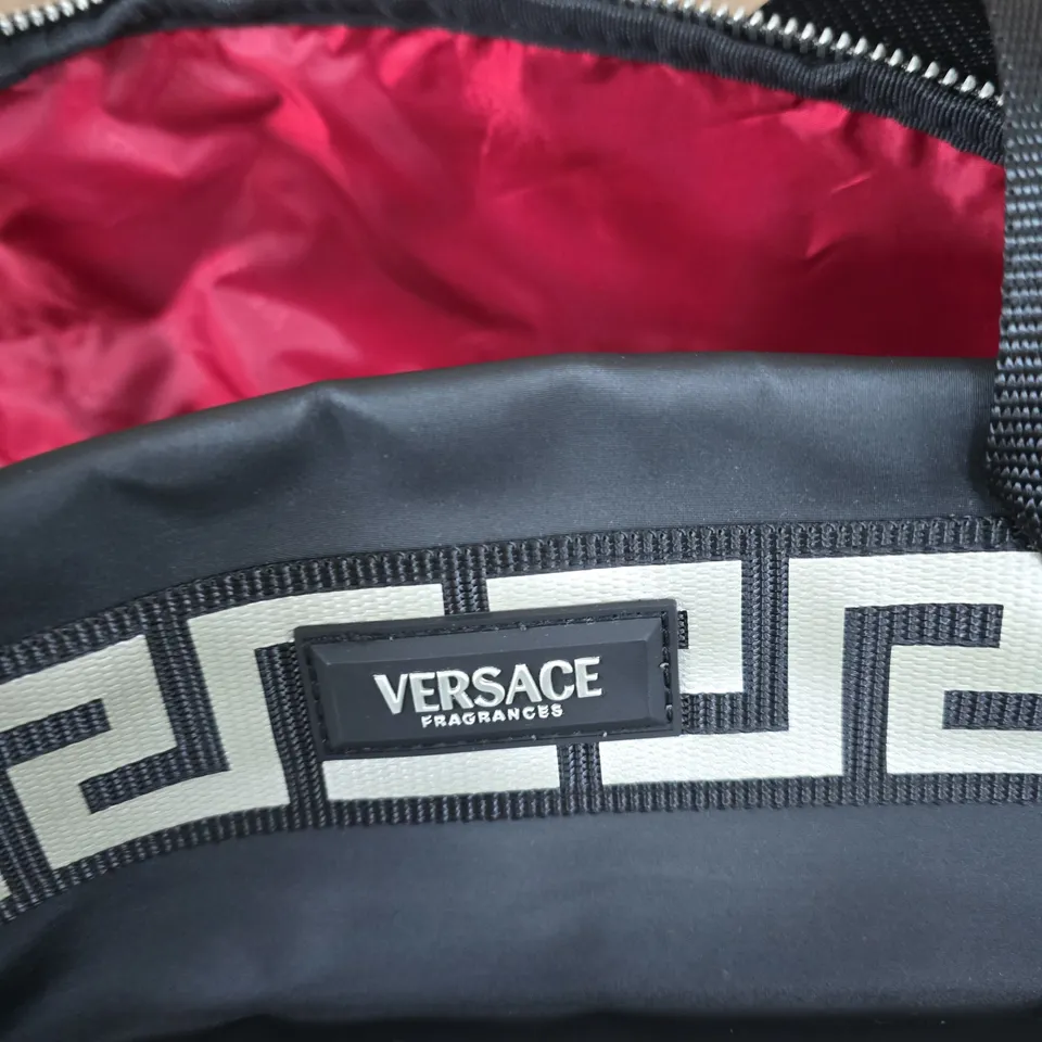 VERSACE FRAGRANCES BLACK DUFFEL BAG WITH GREEK KEY STRAP AND PINK LINING