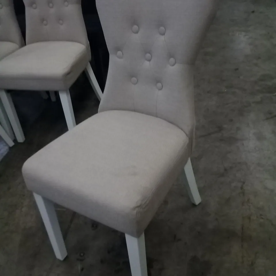 APPROXIMATELY 4 BEIGE FABRIC BUTTON BACK DINING CHAIRS WITH WHITE LEGS