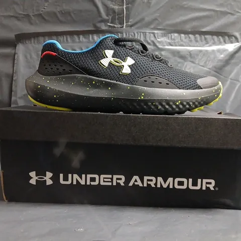 BOXED PAIR OF UNDER ARMOUR BGS SURGE 4 TRAINERS IN BLACK/MULTI SIZE UK 4