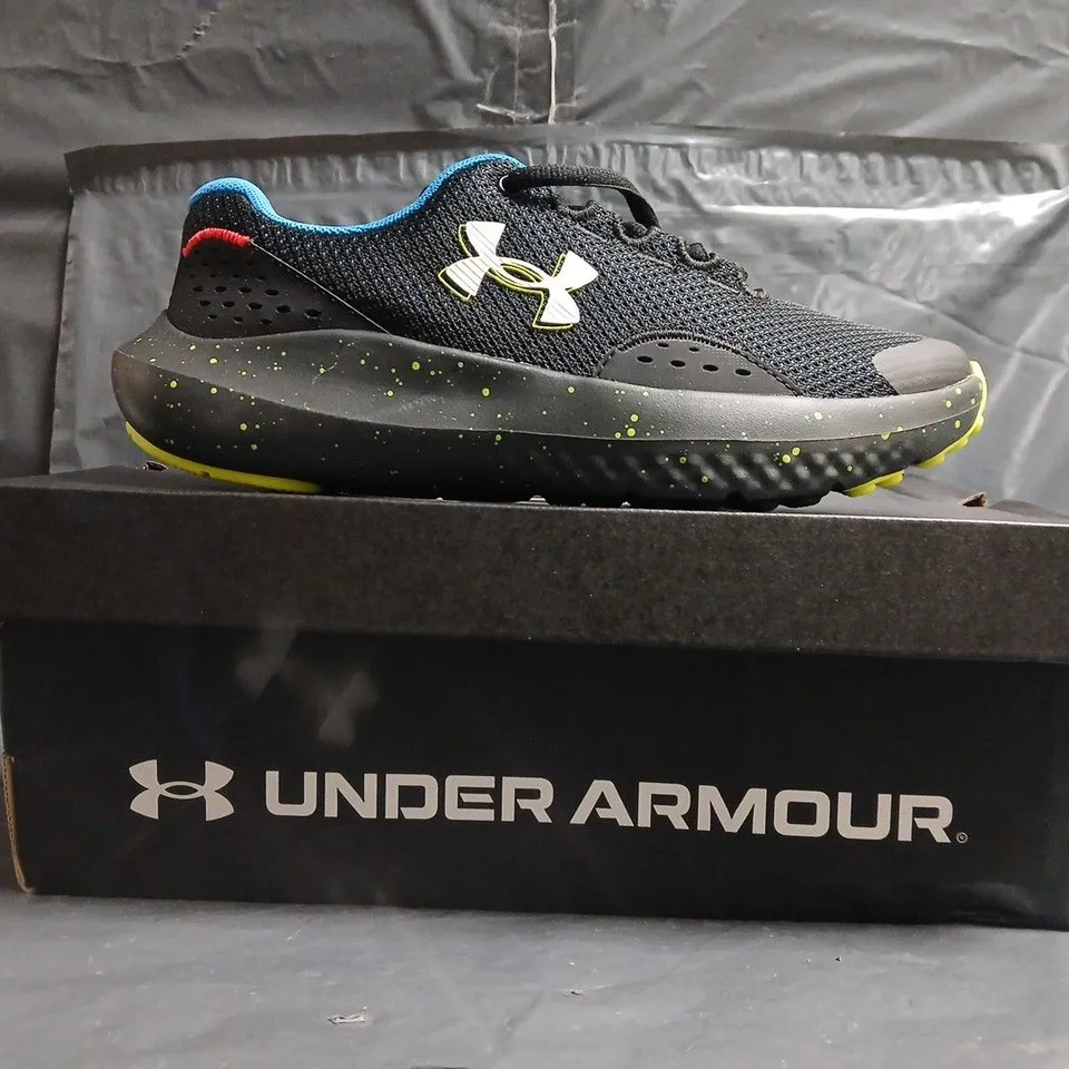 BOXED PAIR OF UNDER ARMOUR BGS SURGE 4 TRAINERS IN BLACK/MULTI SIZE UK 4