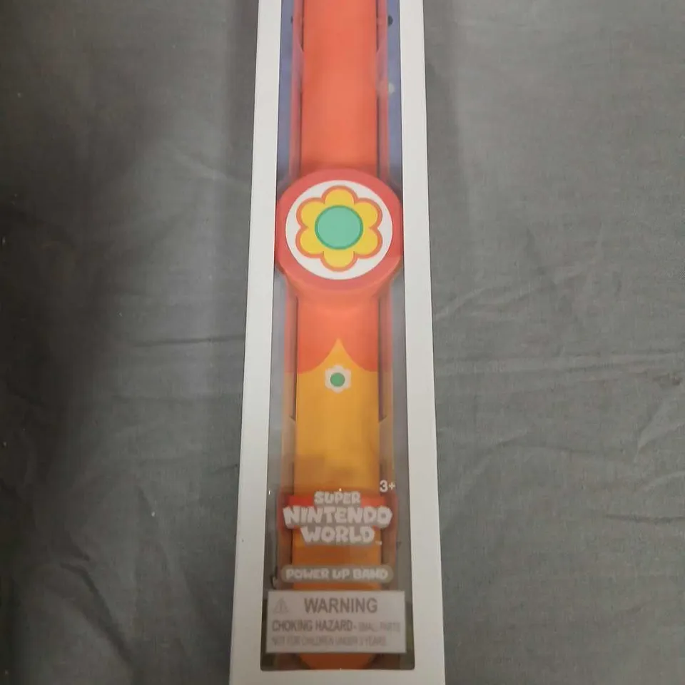 POWER UP BAND – SUPER NINTENDO WORLD, ORANGE WITH FLOWER EMBLEM, IN ORIGINAL PACKAGING
