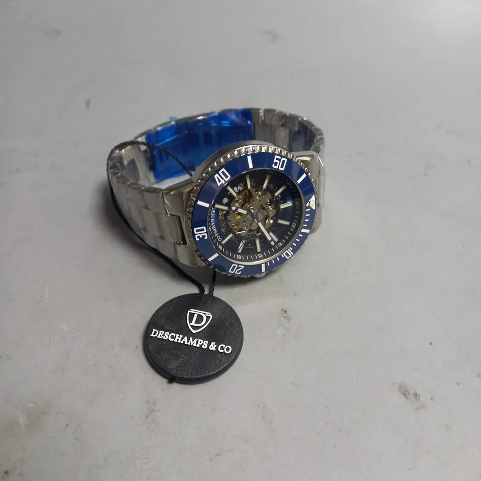 BOXED MENS DESCHAMPS & CO AUTOMATIC WATCH BLUE SKELETON DIAL AND A STAINLESS STEEL STRAP