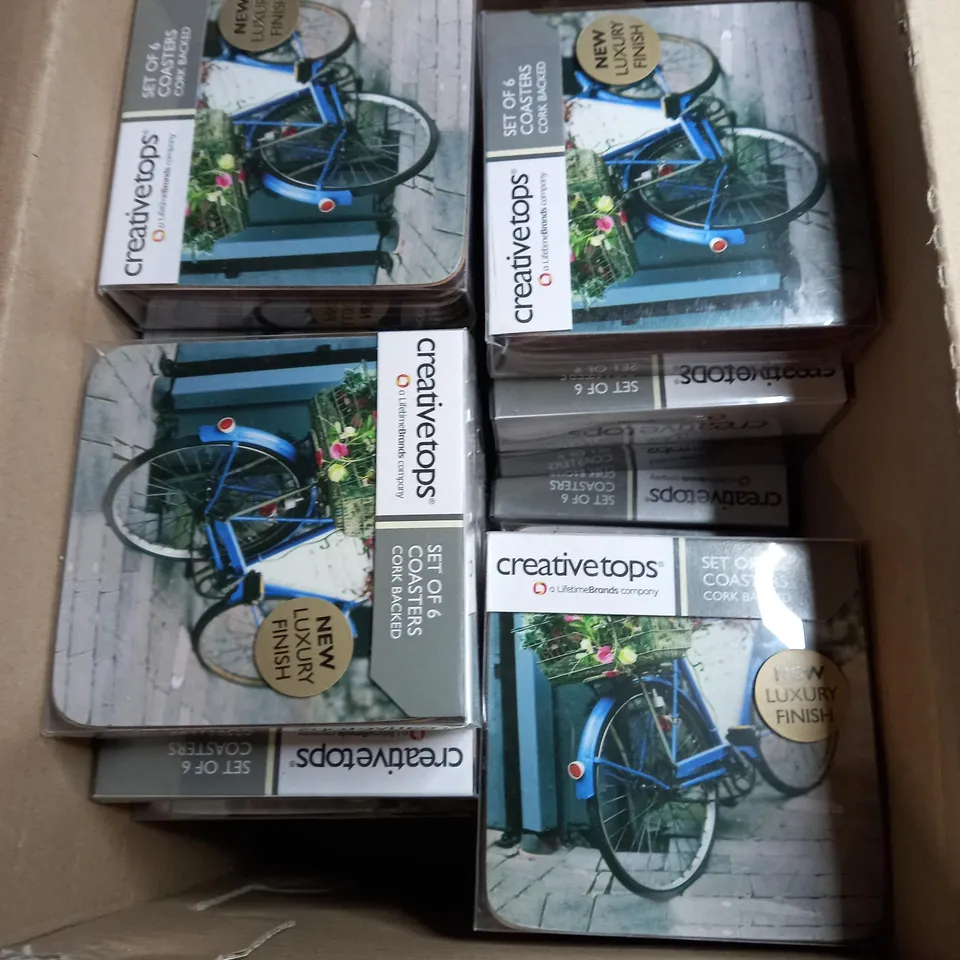 BOX OF APPROXIMATELY 30 PACKS OF CREATIVE TOPS SET OF 6 CORK BACKED COASTERS IN A VINTAGE BICYCLE DESIGN 