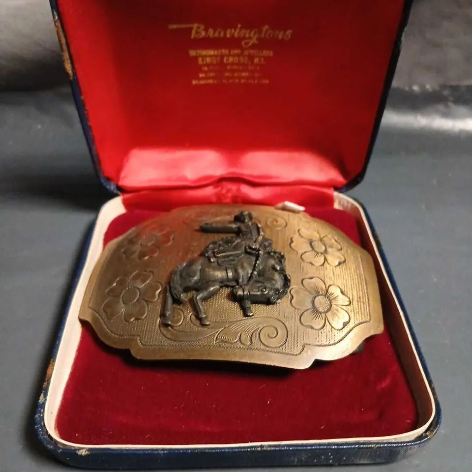 BRASS BELT BUCKLE WITH HORSE & RIDER MOTIF – FLORAL ENGRAVING IN BRAVINGTONS CASE 