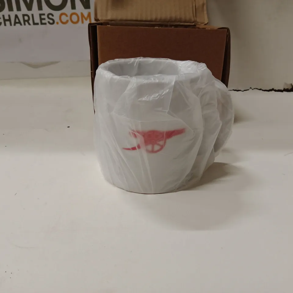 BOXED WHITE CERAMIC MUG WITH RED TEXT READING 'BY FAR THE GREATEST WIFE THE WORLD HAS EVER SEEN'.