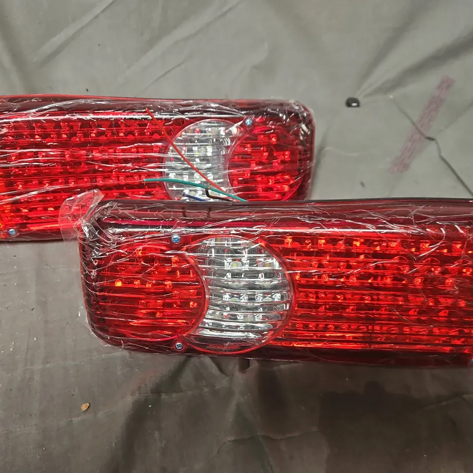 PAIR OF TAIL LIGHT ASSEMBLIES WITH RED LENSES AND AMBER INDICATORS