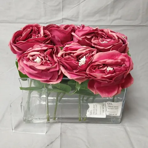 Artificial pink rose arrangement in clear glass vase