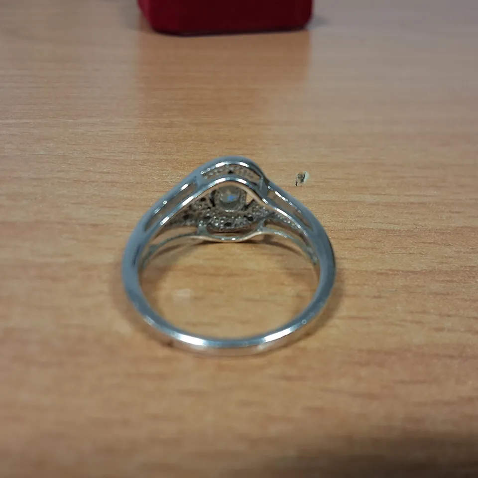 18CT WHITE GOLD RING SET WITH A NATURAL OVAL CUT DIAMOND TO NATURAL DIAMOND HALO
