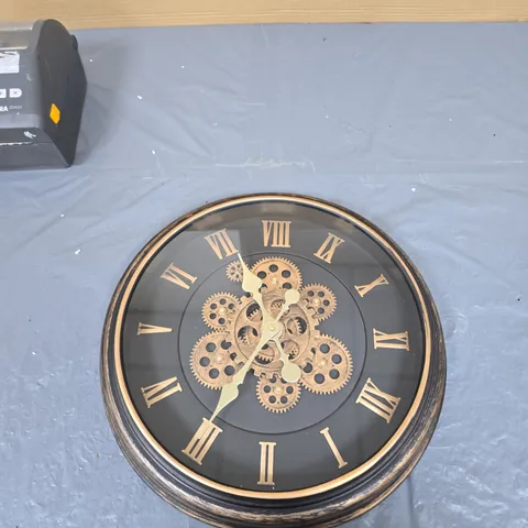 ROUND WALL CLOCK WITH GEAR MOTIF AND ROMAN NUMERALS – BLACK DIAL, GOLD DETAILING