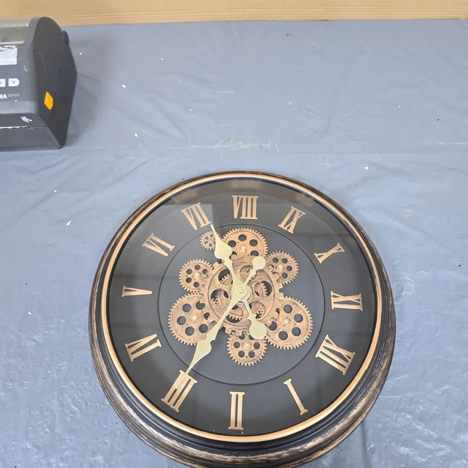 ROUND WALL CLOCK WITH GEAR MOTIF AND ROMAN NUMERALS – BLACK DIAL, GOLD DETAILING