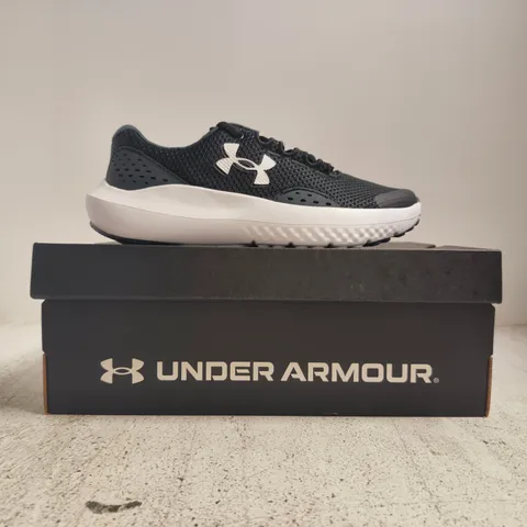BOXED PAIR OF UNDER ARMOUR BGS SURGE 4 TRAINERS IN BLACK/WHITE SIZE UK 3