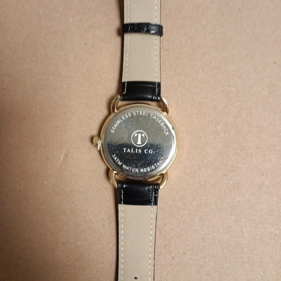 BOXED TALIS CO. WRISTWATCH GOLD-TONE, BLACK DIAL WITH ROMAN NUMERALS, BLACK LEATHER STRAP