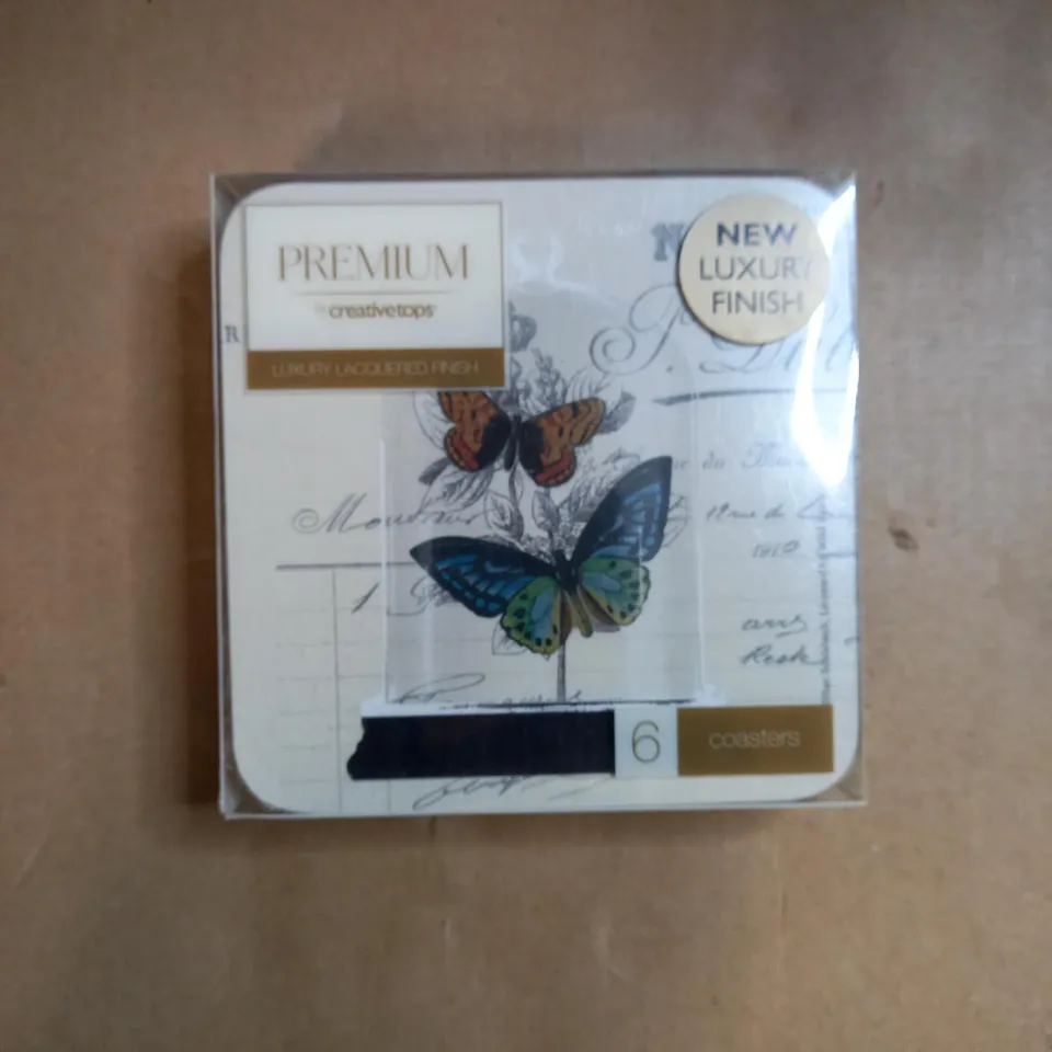 BOX OF APPROXIMATELY 70 PACKS OF CREATIVE TOPS CORK BACKED COASTERS IN A BUTTERFLY DESIGN 