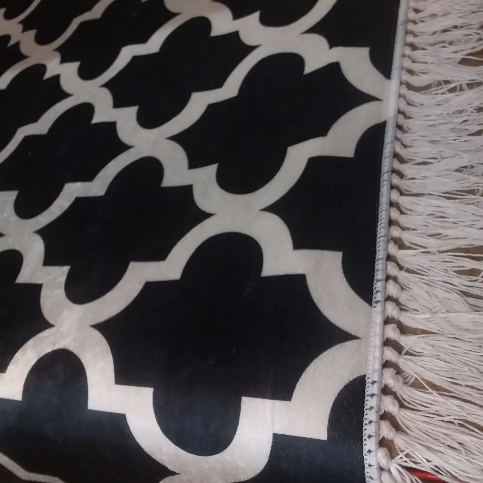  PATTERNED BLACK AND WHITE RUG WITH WHITE TRIM TASSELS 