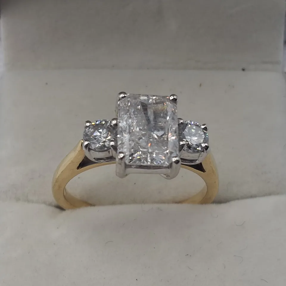 18CT RING SET WITH A NATURAL RADIANT CUT DIAMOND AND A NATURAL DIAMOND TO EACH SHOULDER WEIGHING +-2.46CT