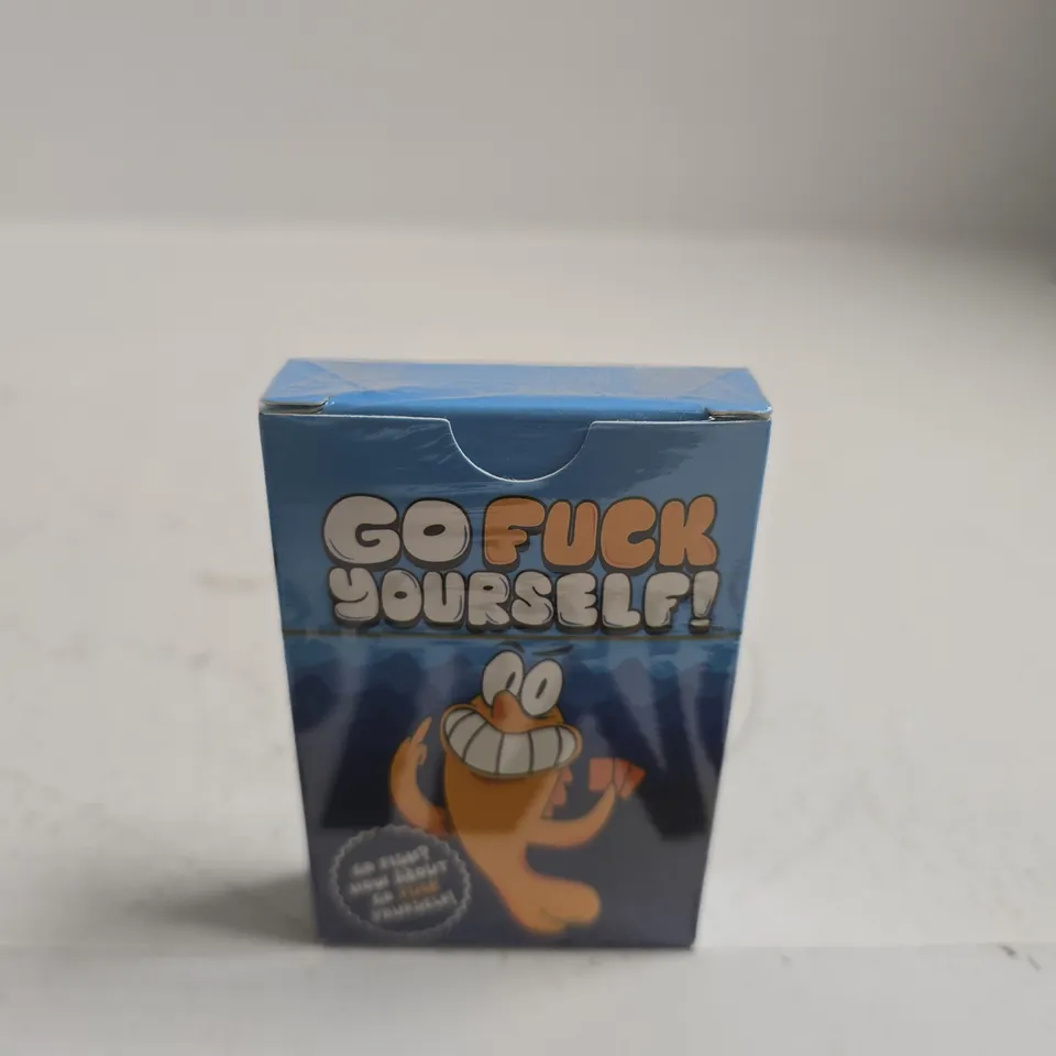 TOTE OF APPROXIMATELY 15 ASSORTED ITEMS INCLUDING YU GI OH TRADING CARDS, GO FUCK YOURSELF CARDS AND PALM PALS TOY