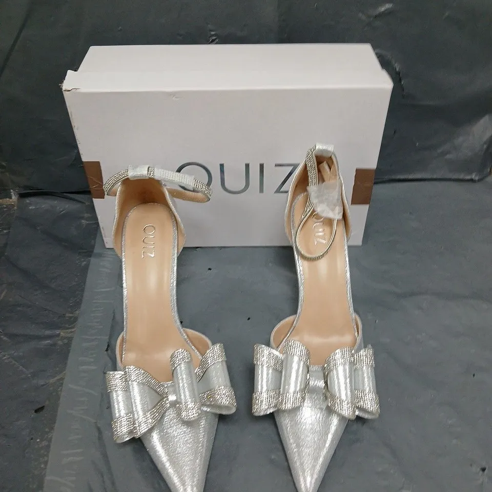 BOXED PAIR OF QUIZ BOW HIGH JEWELLED SILVER HEELS - SIZE 6 