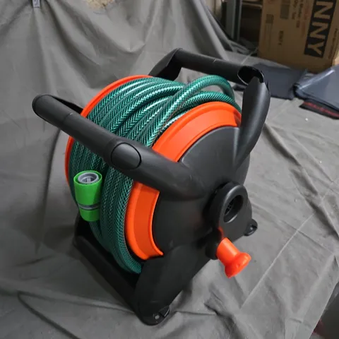 GARDEN HOSE REEL WITH GREEN HOSE, ORANGE DRUM AND SPRAY NOZZLE