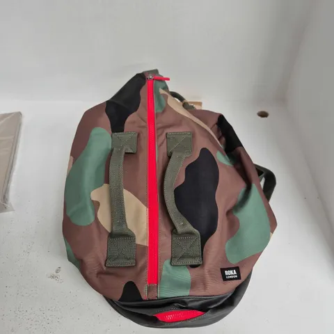 ROKA LONDON CAMOUFLAGE ROUND BAG WITH RED ZIP AND WEBBING STRAPS