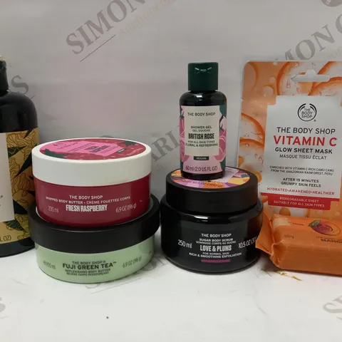 LOT OF 7 ASSORTED THE BODY SHOP PRODUCTS TO INCLUDE GINGER ANTI-DANDRUFF SHAMPOO, FRESH RASPBERRY BODY BUTTER, VITAMIN C SHEET MASK, ETC