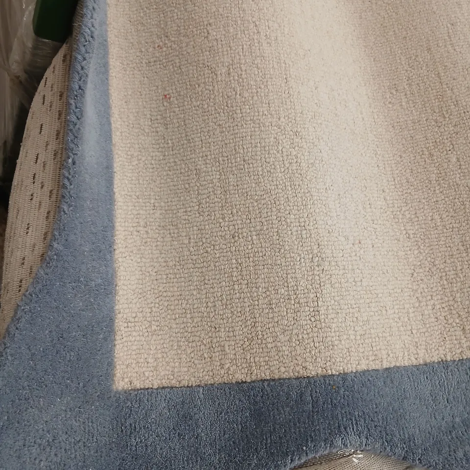 LARGE CREAM RUG WITH BLUE BORDER AND WAVY EDGES