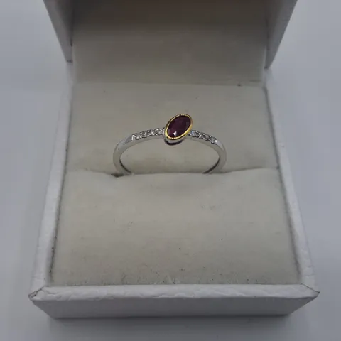 18CT GOLD RING WITH AN OFF-SET ROB OVER OVAL CUT RUBY AND NATURAL DIAMONDS TO EACH SHOULDER
