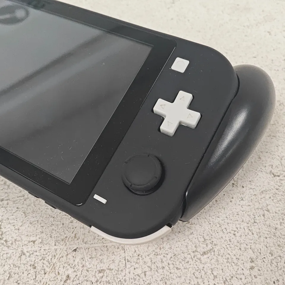 UNBOXED NINTENDO SWITCH LITE HANDHELD GAMING CONSOLE IN BLACK WITH ATTACHED CONTROLLER SUPPORT
