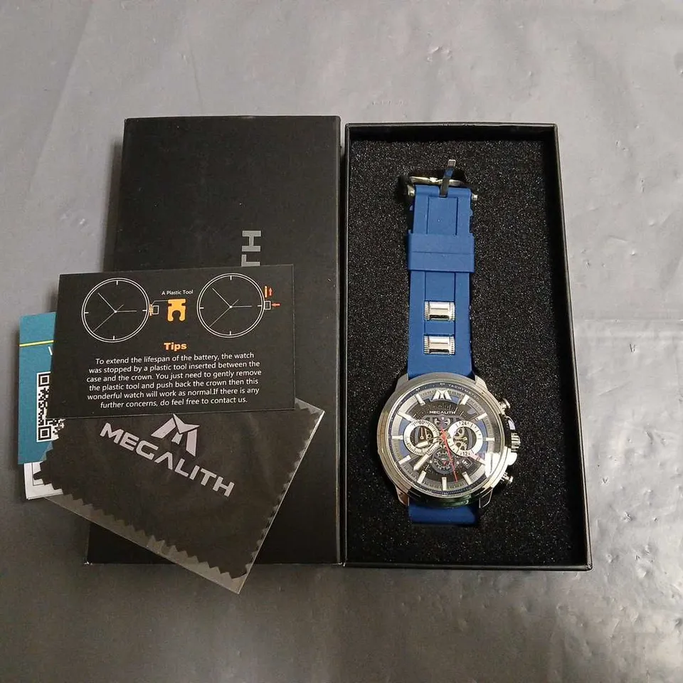 BOXED MEGALITH SKELETON FACED GENTS WATCH WITH STAINLESS STEEL BACK AND BLUE RUBBER STRAP